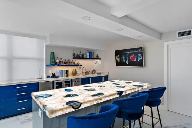 a dining table with white cabinets and wooden floor