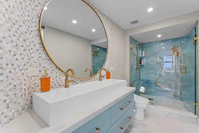 a bathroom with a sink a toilet and shower