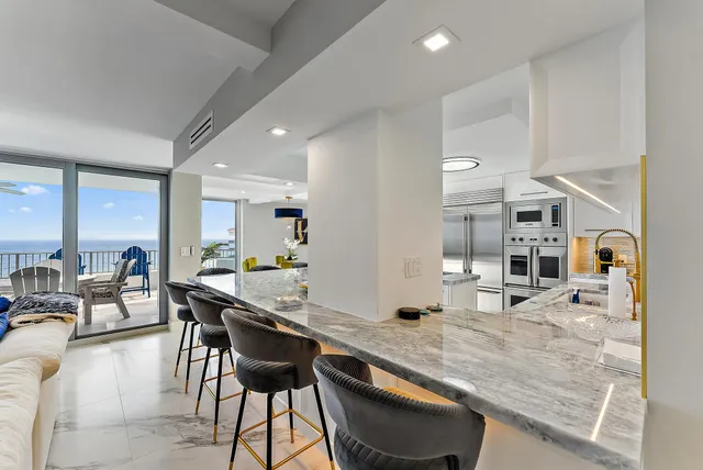 a kitchen with stainless steel appliances granite countertop table chairs sink and cabinets
