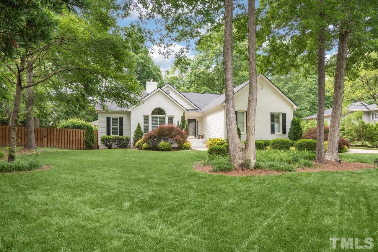 a front view of a house with a yard and trees