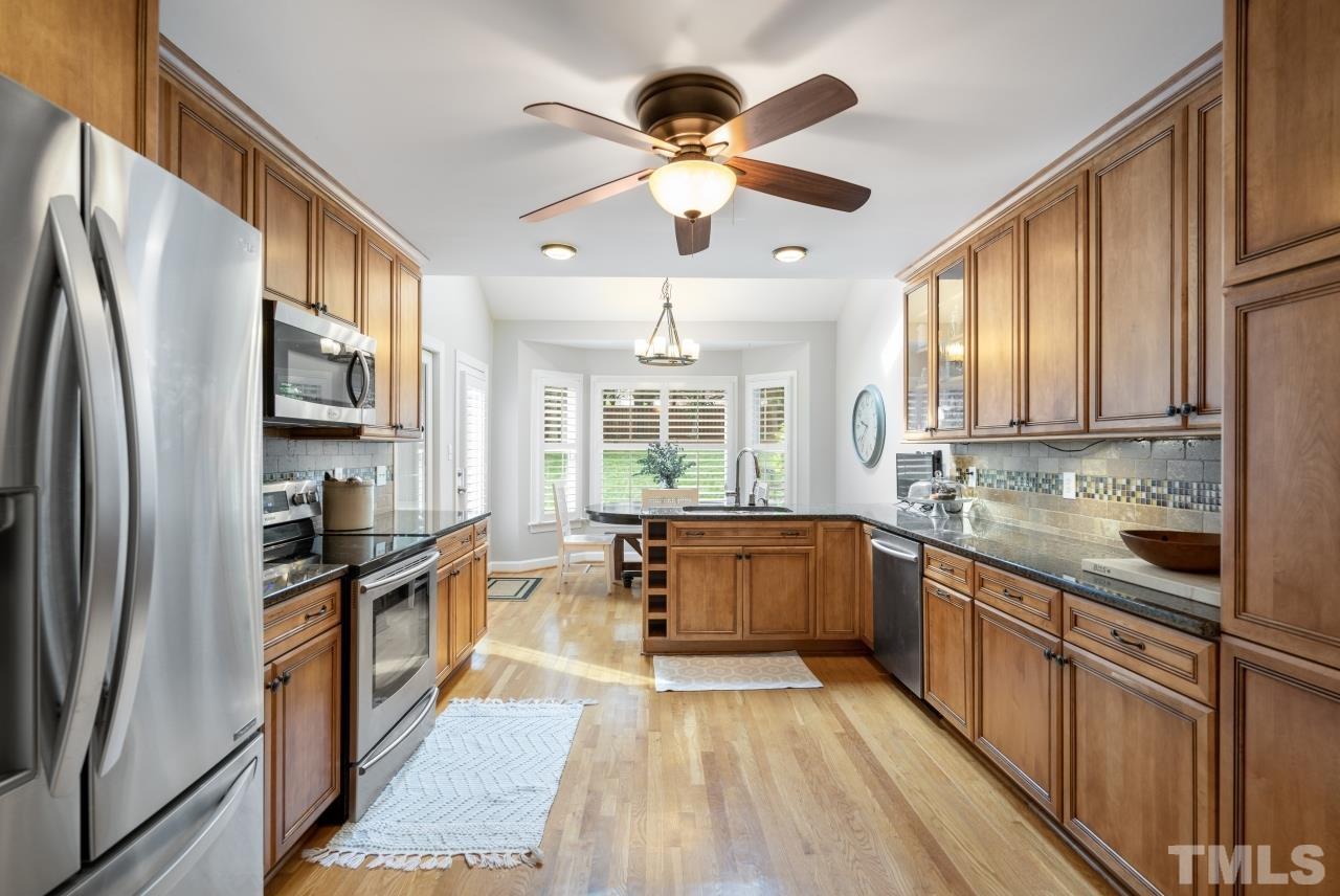 4401 Touchstone Forest Road Raleigh, NC 27612 - Photo 13 of 44 a kitchen with stainless steel appliances granite countertop a stove refrigerator sink and dishwasher with wooden floor