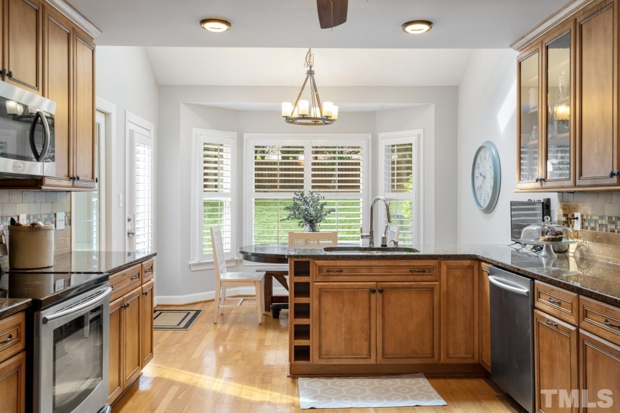 4401 Touchstone Forest Road Raleigh, NC 27612 - Photo 14 of 44 a kitchen with stainless steel appliances granite countertop a stove a sink and a refrigerator