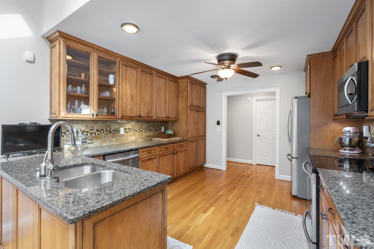 4401 Touchstone Forest Road Raleigh, NC 27612 - Photo 15 of 44 a kitchen with granite countertop a sink a counter top space and cabinets