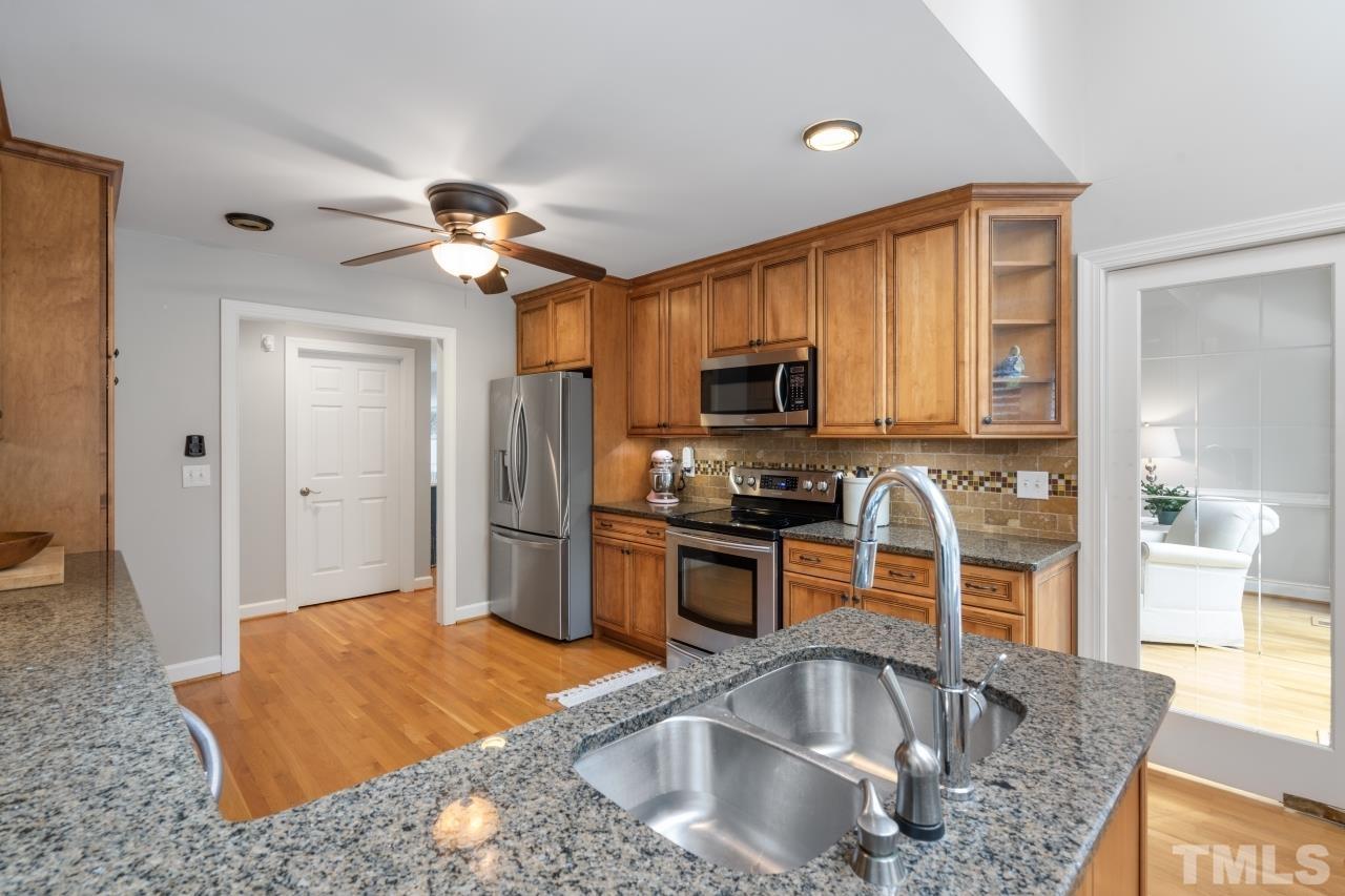 4401 Touchstone Forest Road Raleigh, NC 27612 - Photo 16 of 44 a kitchen with stainless steel appliances granite countertop a sink a stove and a refrigerator