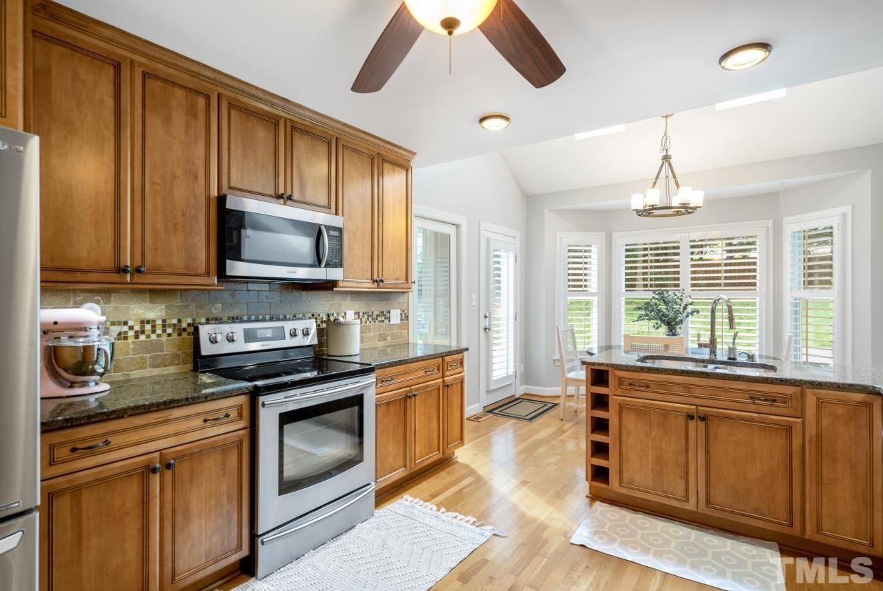 4401 Touchstone Forest Road Raleigh, NC 27612 - Photo 17 of 44 a kitchen with stainless steel appliances granite countertop a stove a sink and a microwave