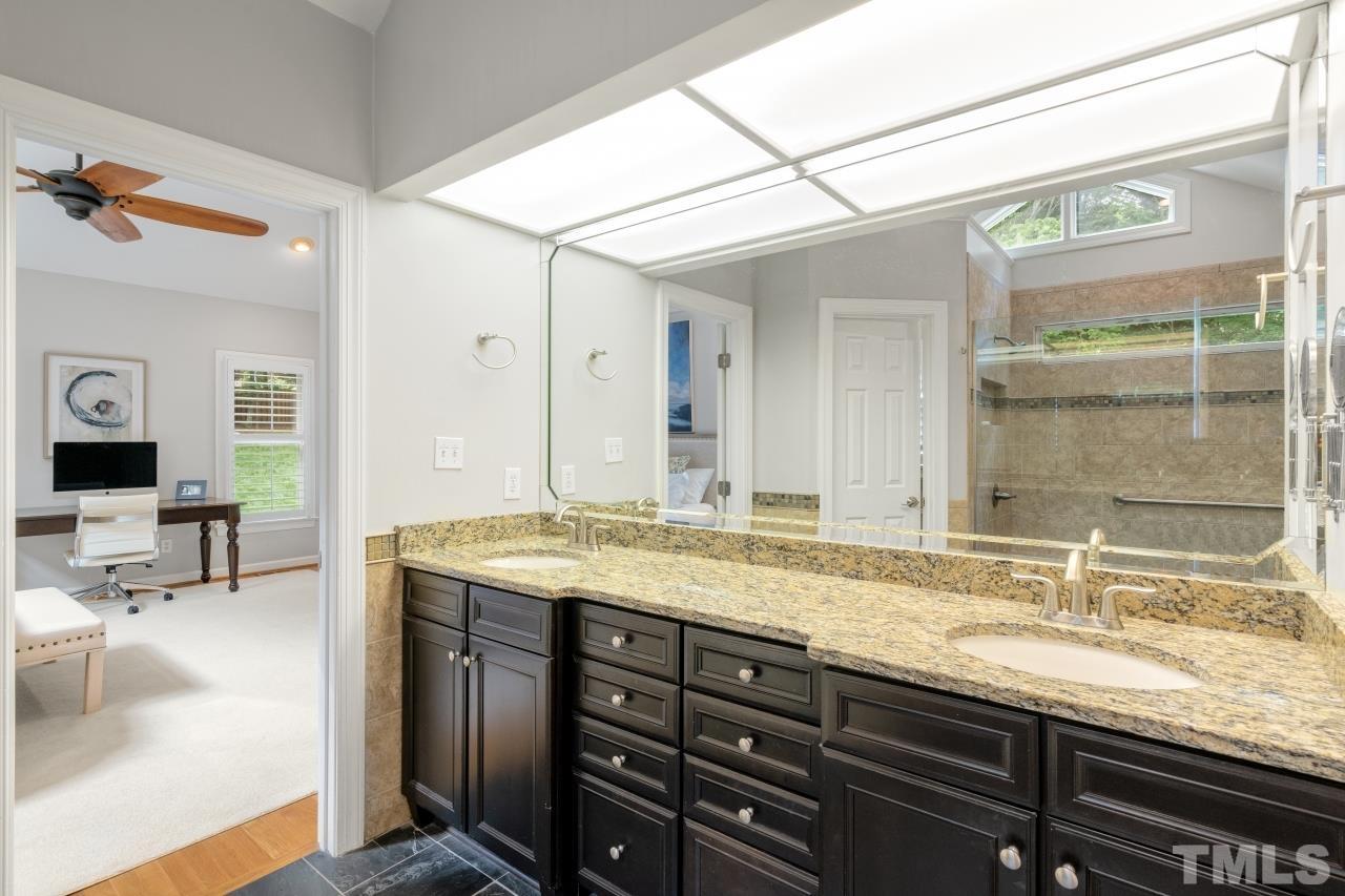 4401 Touchstone Forest Road Raleigh, NC 27612 - Photo 22 of 44 a bathroom with a granite countertop sink and a mirror