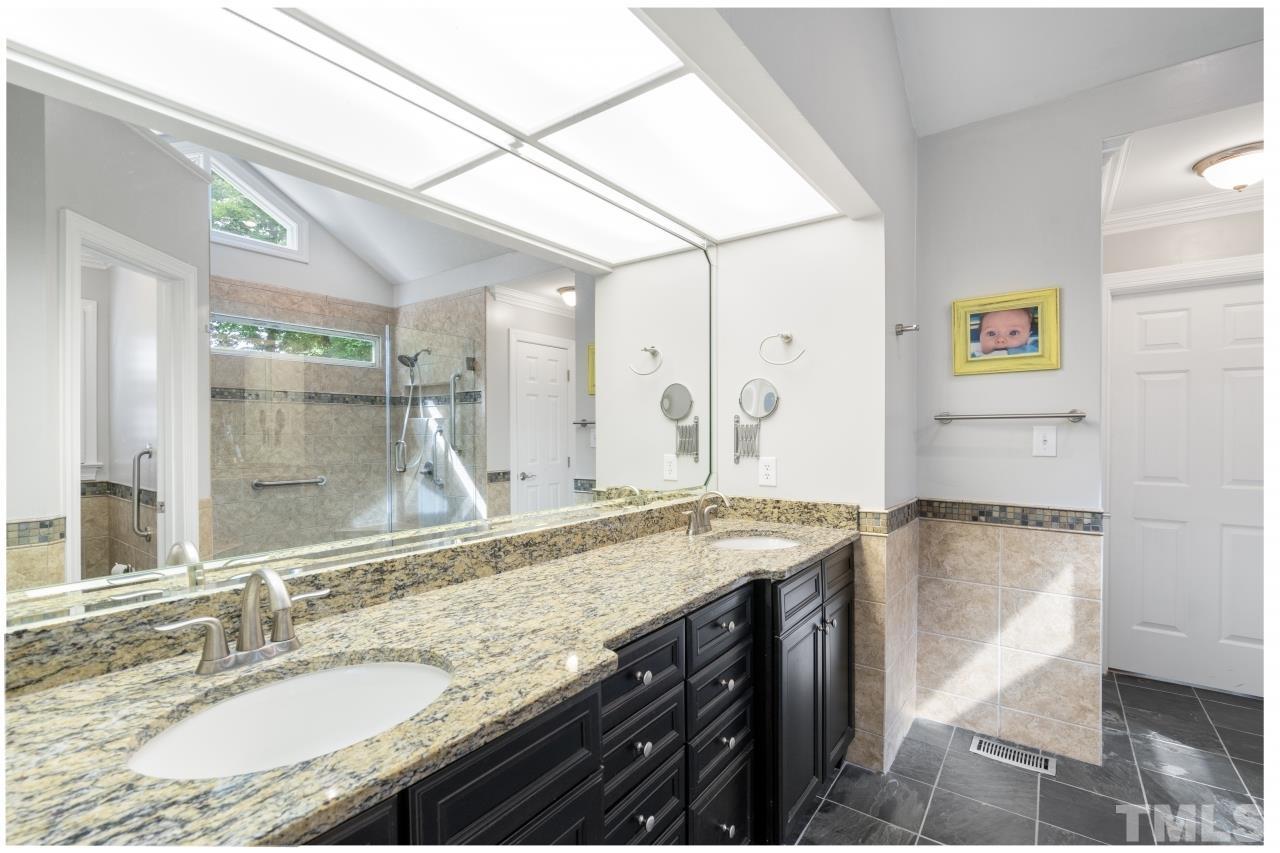 4401 Touchstone Forest Road Raleigh, NC 27612 - Photo 24 of 44 a bathroom with a granite countertop sink a mirror and a