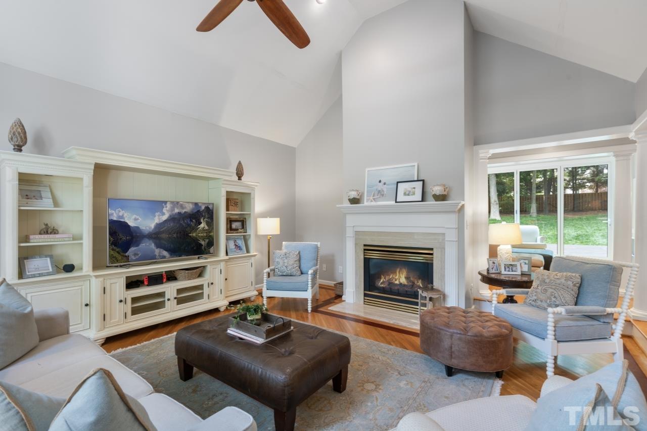 4401 Touchstone Forest Road Raleigh, NC 27612 - Photo 5 of 44 a living room with furniture a flat screen tv and a fireplace