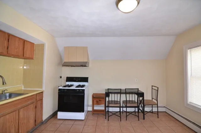 a kitchen with granite countertop a stove a sink and a refrigerator