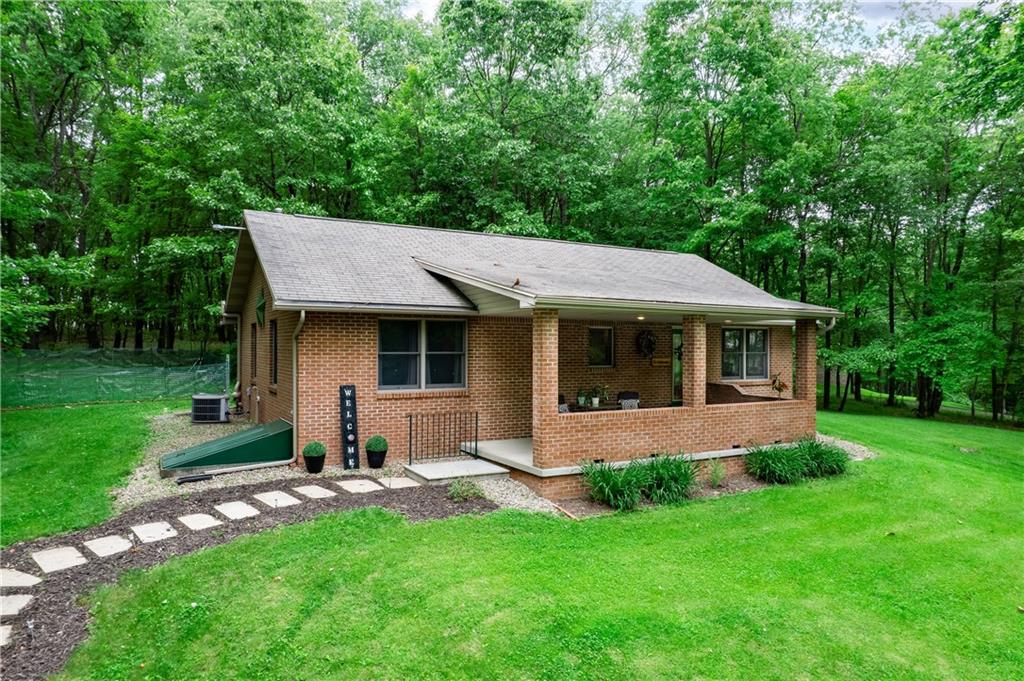 a view of a house with a yard and sitting area
