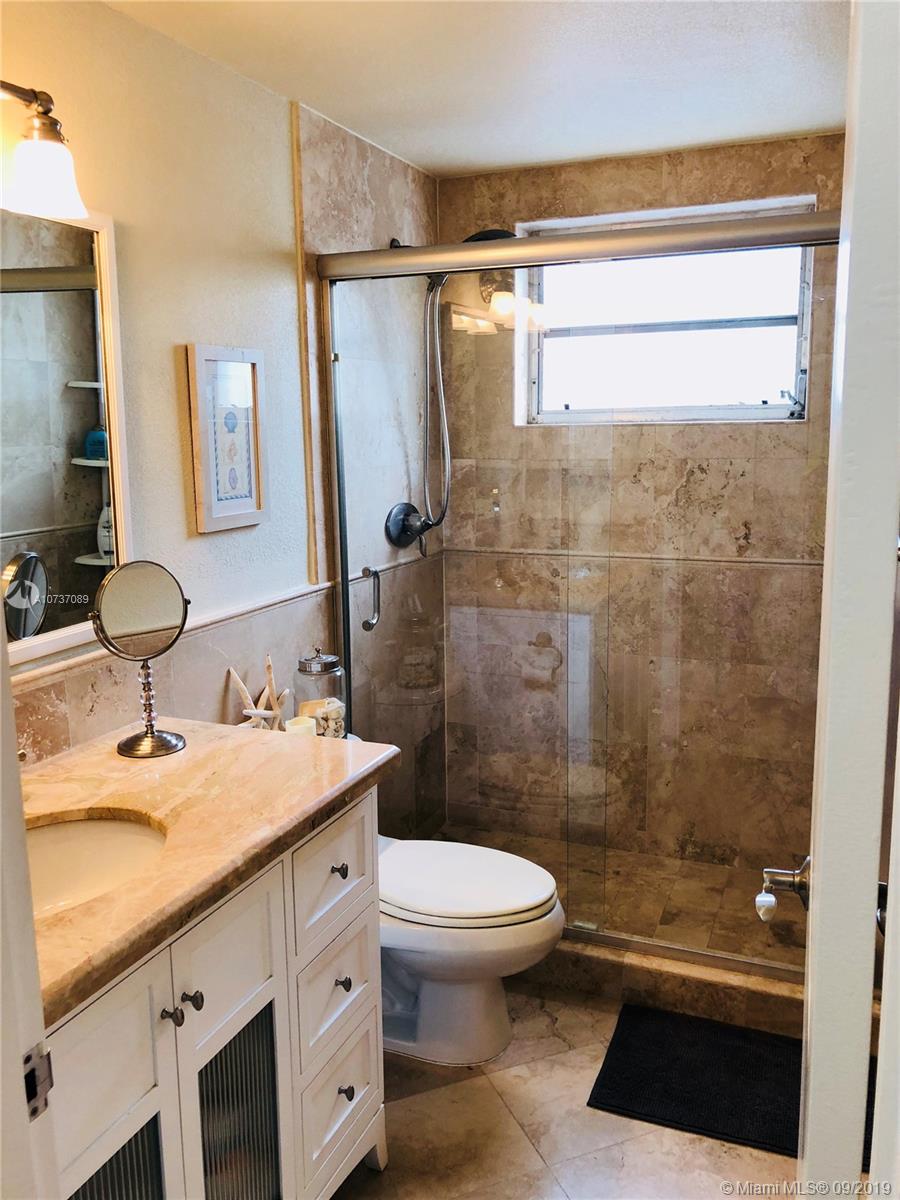 201 Sunrise Drive, Unit 109 Key Biscayne, FL 33149 - Photo 11 of 14 a bathroom with a sink a toilet and shower