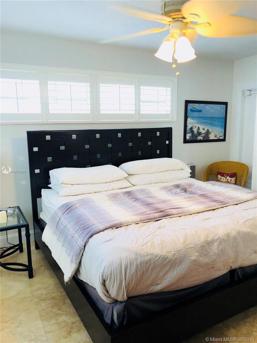 201 Sunrise Drive, Unit 109 Key Biscayne, FL 33149 - Photo 12 of 14 a bedroom with a bed and a chandelier