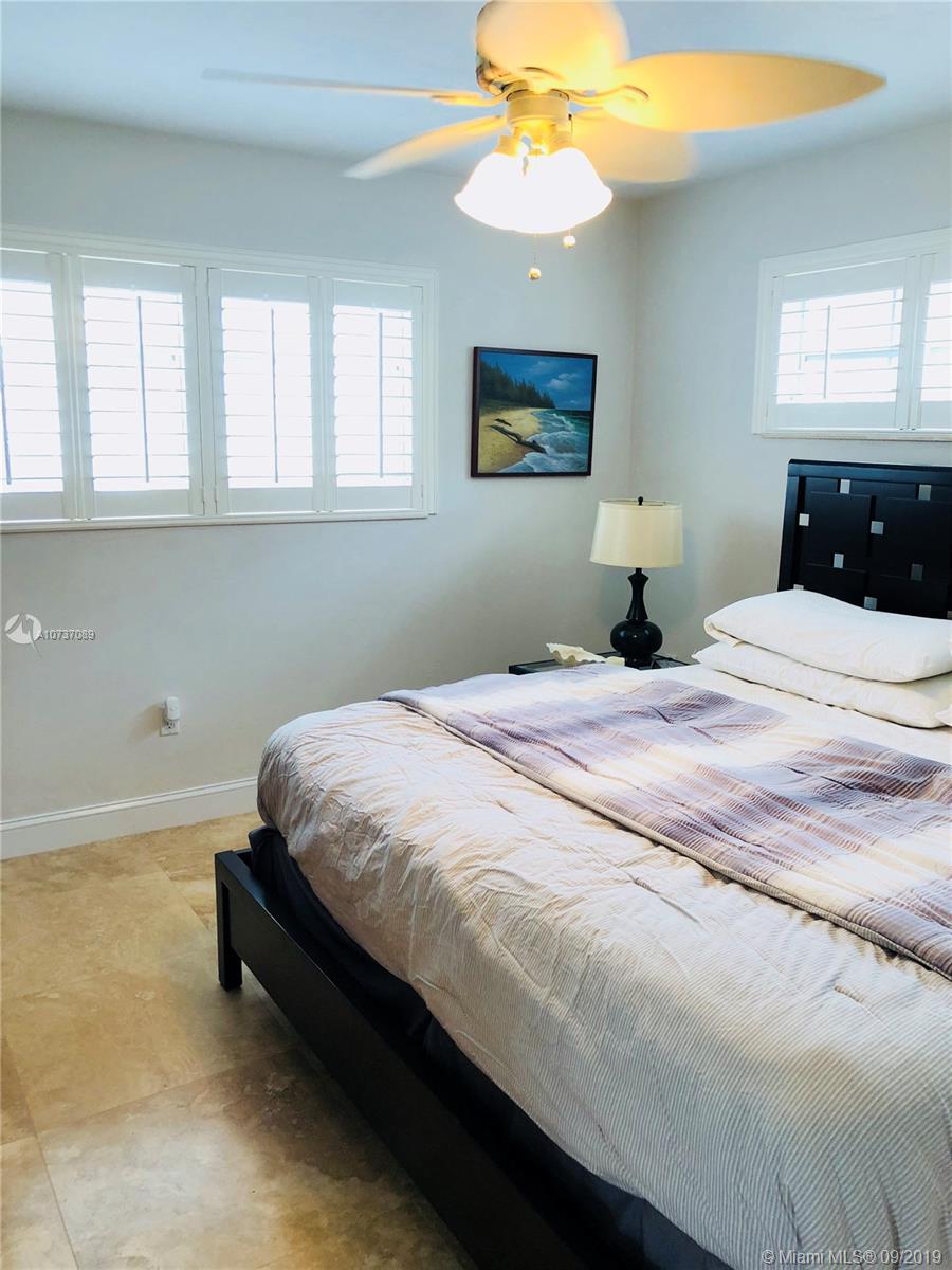 201 Sunrise Drive, Unit 109 Key Biscayne, FL 33149 - Photo 13 of 14 a bedroom with a bed and a chandelier