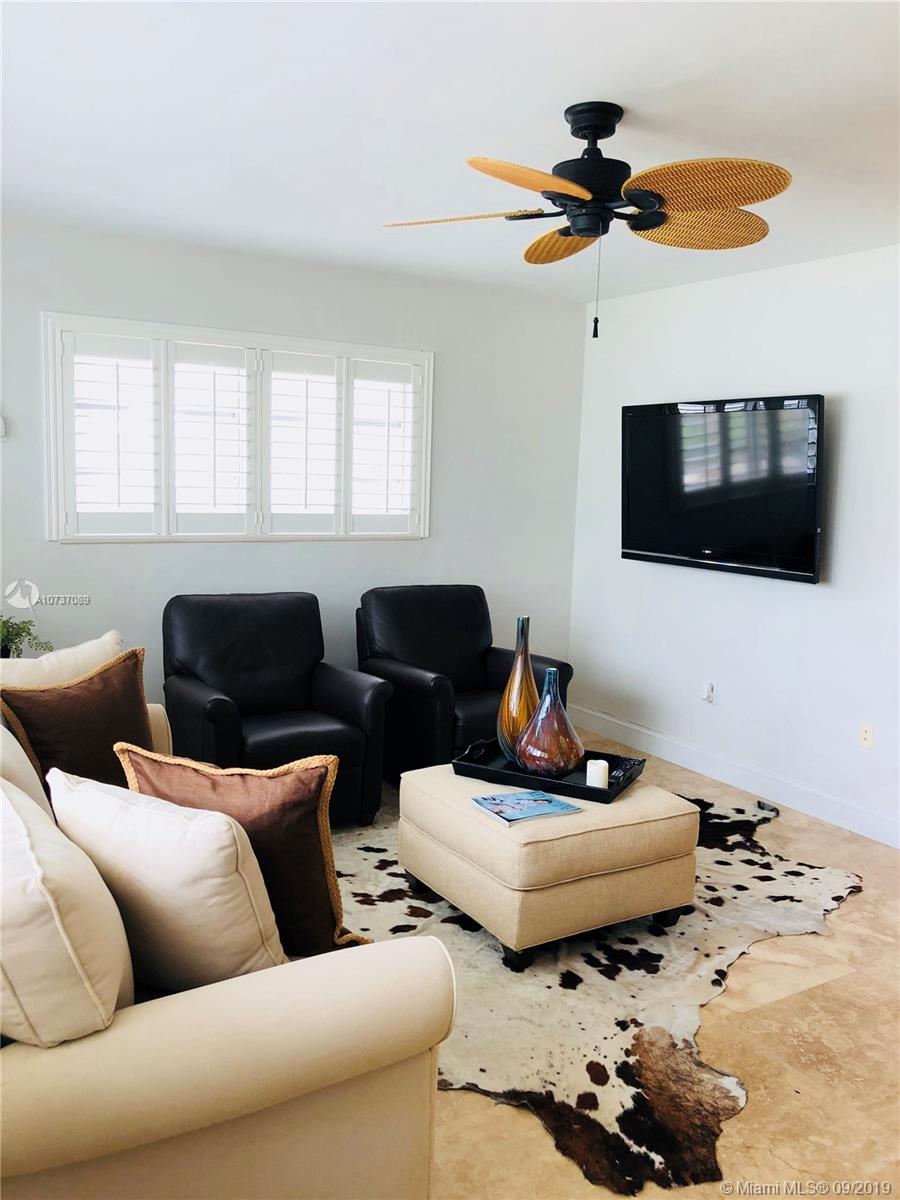 201 Sunrise Drive, Unit 109 Key Biscayne, FL 33149 - Photo 3 of 14 a living room with furniture and a flat screen tv