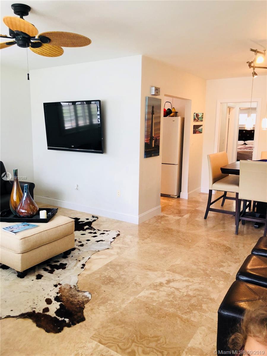 201 Sunrise Drive, Unit 109 Key Biscayne, FL 33149 - Photo 5 of 14 a living room with furniture and a flat screen tv