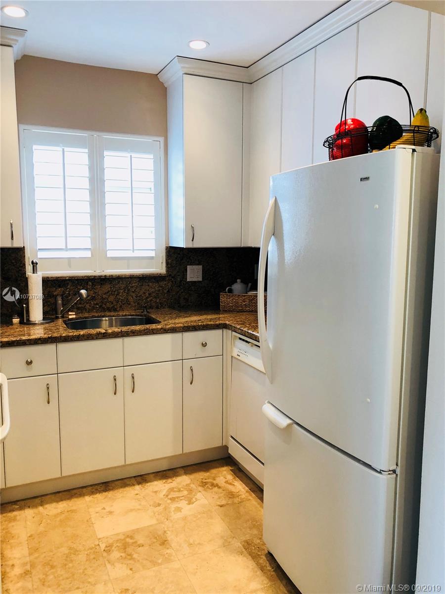 201 Sunrise Drive, Unit 109 Key Biscayne, FL 33149 - Photo 8 of 14 a kitchen with a refrigerator and a stove top oven