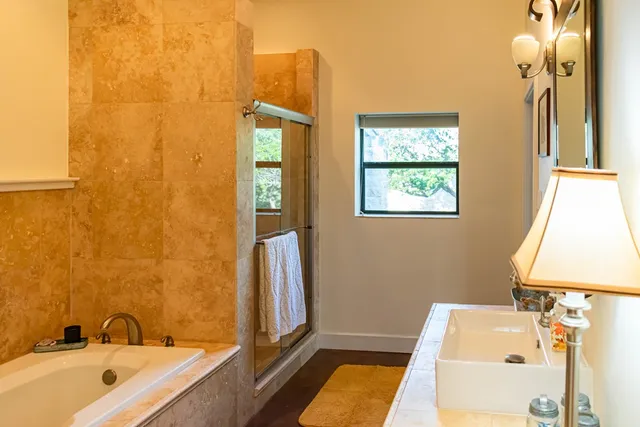 a bathroom with a tub sink and mirror