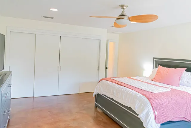 a bedroom with a bed and a ceiling fan