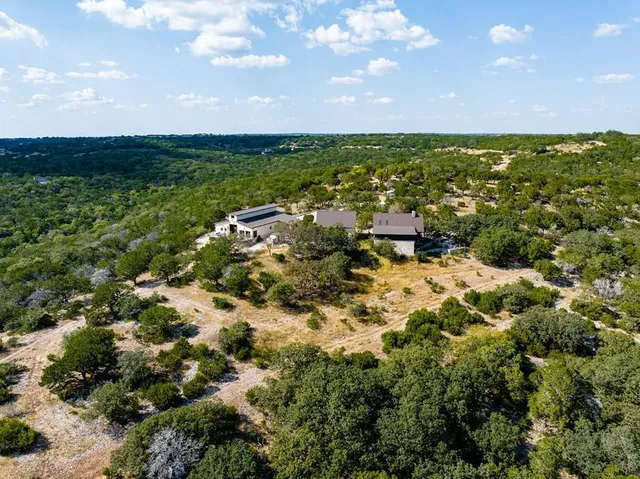 an aerial view of residential houses with outdoor space and trees