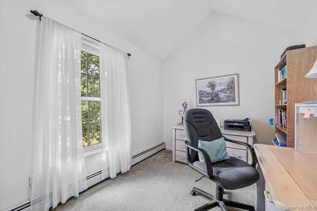 a view of a workspace with furniture and a window