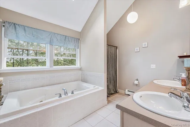 a bathroom with a tub sink and mirror