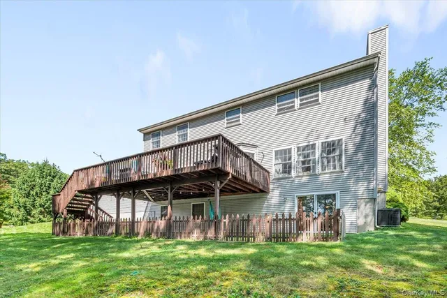 a view of a house with a yard and deck
