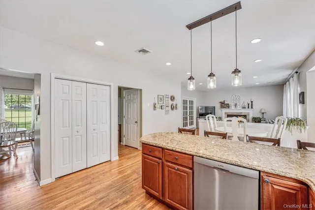 a kitchen with granite countertop a sink cabinets and wooden floor