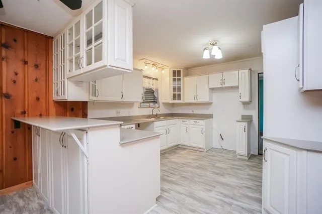 a kitchen with white cabinets appliances and a sink
