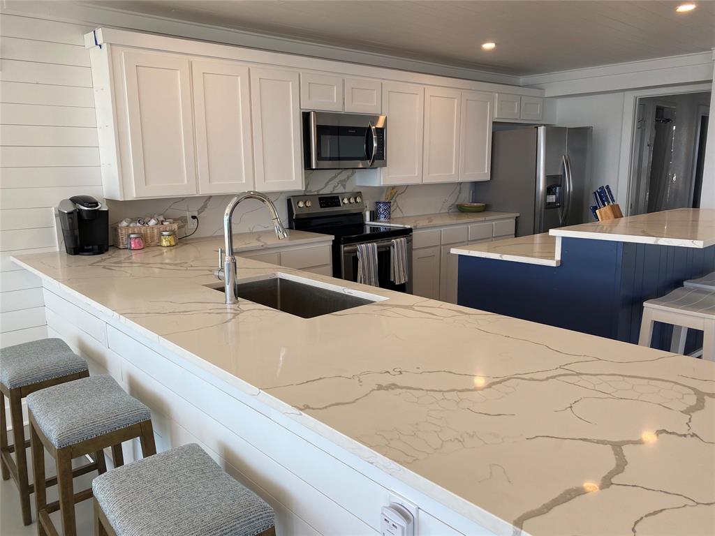 4415 Chapel Road Graham, TX 76450 - Photo 11 of 40 a kitchen with stainless steel appliances a sink a stove top oven a counter space and cabinets