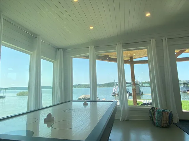 a view of an empty room with wooden floor and a floor to ceiling window