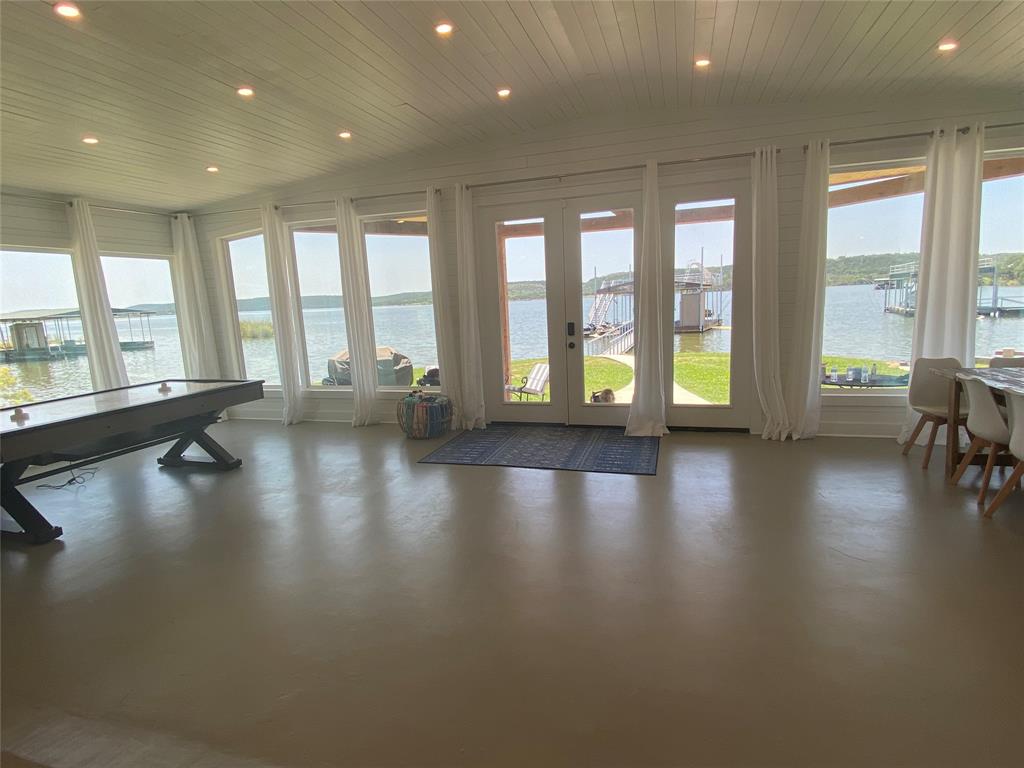4415 Chapel Road Graham, TX 76450 - Photo 14 of 40 a view of an empty room with wooden floor and a floor to ceiling window