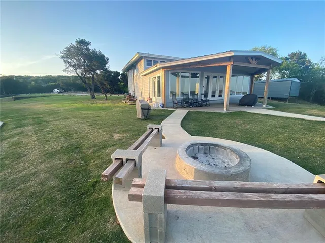 a large kitchen with kitchen island a stove a sink dishwasher a dining table and wooden floor