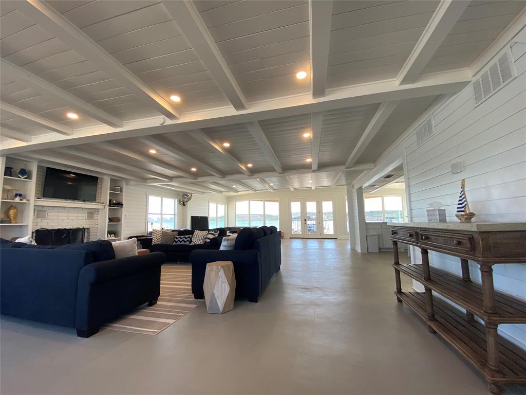4415 Chapel Road Graham, TX 76450 - Photo 10 of 40 a living room with furniture a chandelier a fireplace and a projector