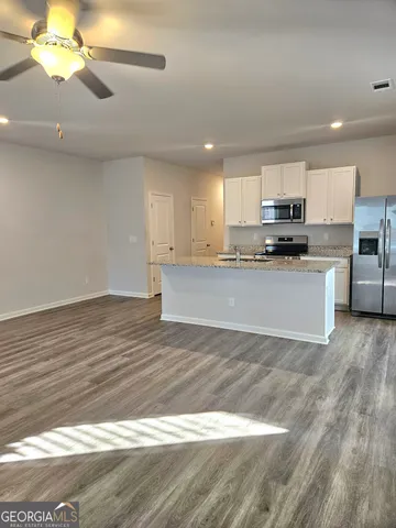 a view of kitchen with wooden floor and electronic appliances