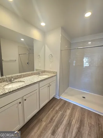 a bathroom with a granite countertop sink a toilet and shower