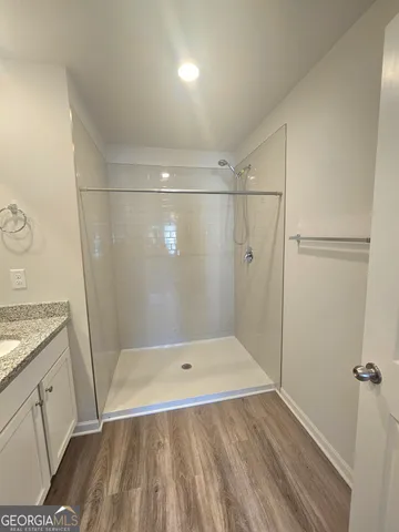 a bathroom with a granite countertop shower and a sink