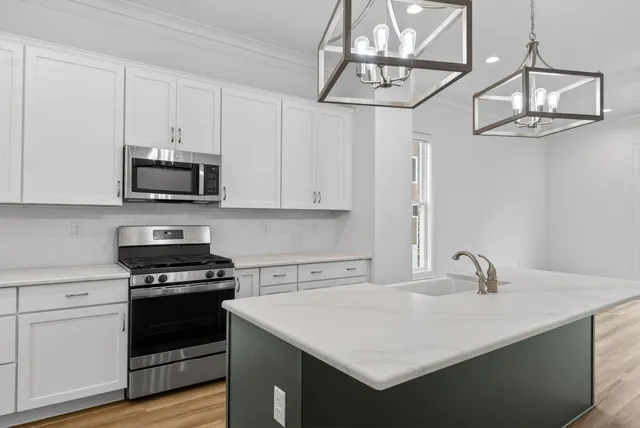 a kitchen with stainless steel appliances a stove sink microwave and cabinets