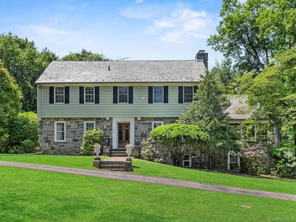 a front view of a house with a garden and plants