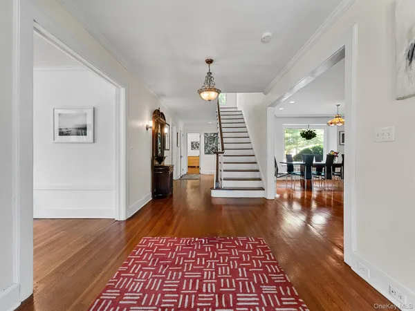 a view of a hallway with wooden floor windows and a chandelier