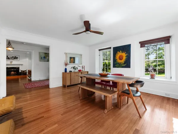 a living room with furniture two window and wooden floor