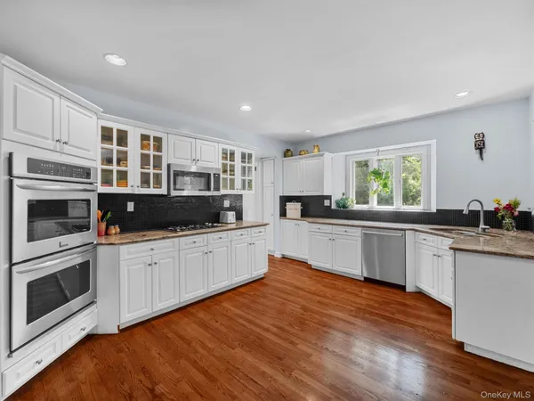 a kitchen with stainless steel appliances kitchen island granite countertop a stove a sink and a microwave