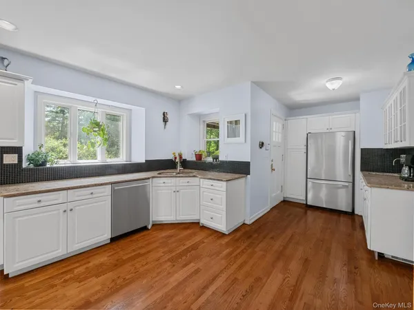 a kitchen with stainless steel appliances white cabinets and wooden floors