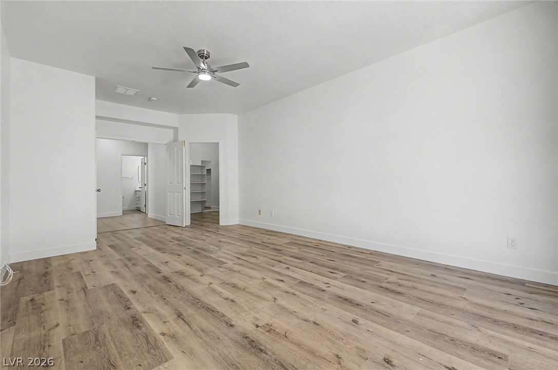 835 Entrada Ridge Avenue Henderson, NV 89012 - Photo 15 of 34 A spacious room features a ceiling fan, durable vinyl plank flooring, and a convenient walk-in closet.