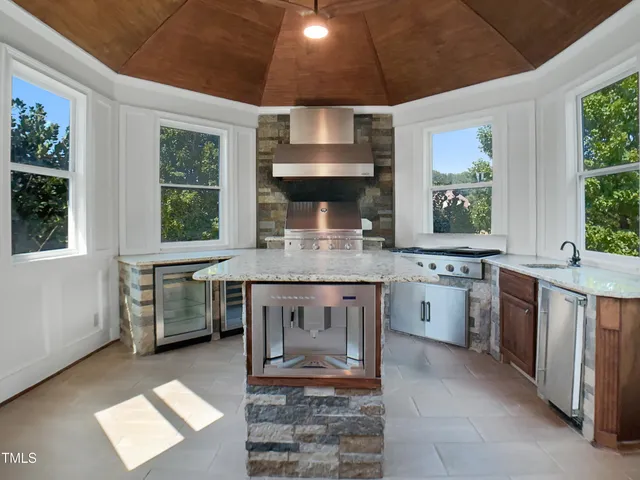 a kitchen with a stove a sink and a wooden cabinets