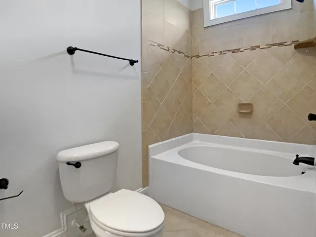 a white toilet sitting next to a bath tub and a shower