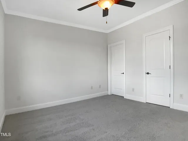 an empty room with a chandelier fan and a ceiling fan