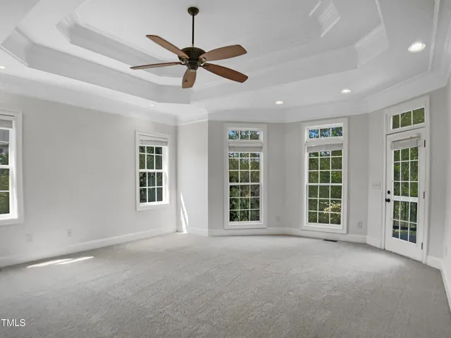 a view of an empty room with a window and a ceiling fan