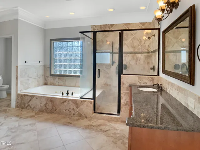 a bathroom with a tub a mirror and a shower