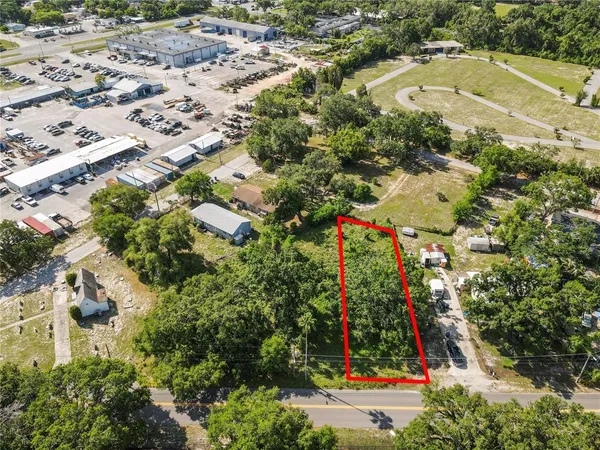 an aerial view of residential houses with outdoor space and trees
