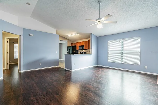 a view of a kitchen with wooden floor and a ceiling fan
